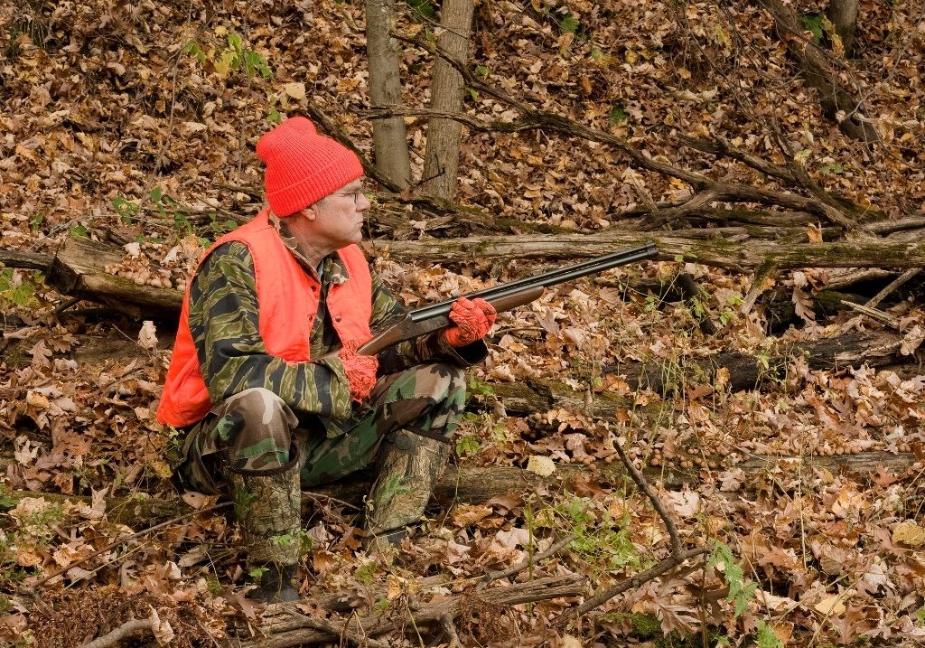 Hunter wearing Camo and Blaze Orange Vest